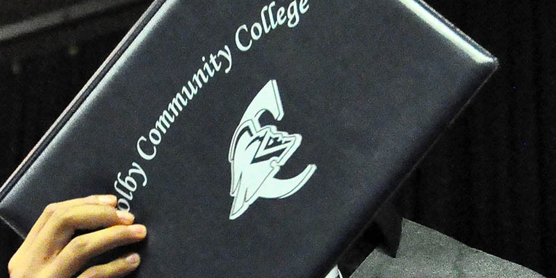 Student holding a CCC diploma cover