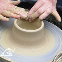 Hands forming art on a pottery wheel