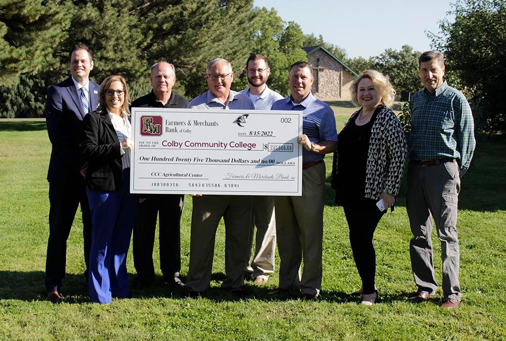 CCC staff and Farmers and Merchants Bank staff with a giant check for $125,000
