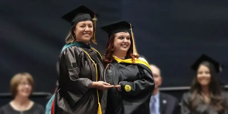 Macey Batie, right, receives the Tangeman Award for Teaching Excellence from Health Sciences Division Chair Meghann Corder.